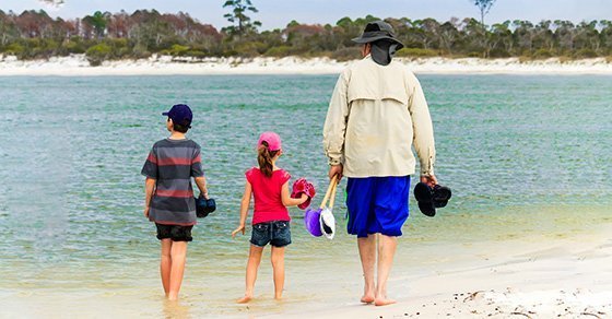 dad and kids walking on the beach