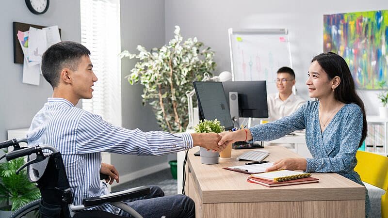 Man,Sits,In,Wheelchair,At,Desk,In,An,Office,,Opposite Man,Sits,In,Wheelchair,At,Desk,In,An,Office,,Opposite
