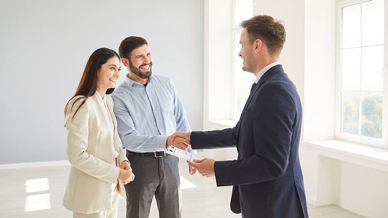Family,Couple,Shakes,Hands,With,A,Real,Estate,Agent,Or